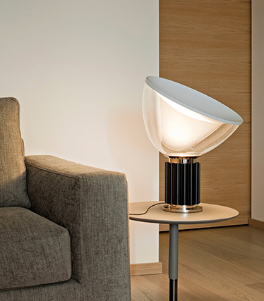 Hedendaagse designlamp die zacht omgevingslicht verspreidt naast een moderne sofa