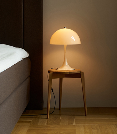 Klassieke paddenstoelvormige bedlamp die zacht licht verspreidt in een knusse slaapkamer