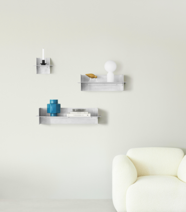 Transparante Normann Copenhagen wandplanken met decoratieve accessoires in een minimalistische woonruimte.