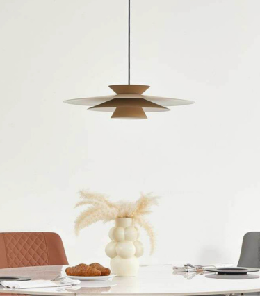 Moderne hanglamp boven eettafel met warme natuurtinten en tijdloos design.