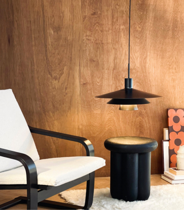 Dyberg Larsen hanglamp boven bijzettafel en fauteuil in een gezellige sfeer.